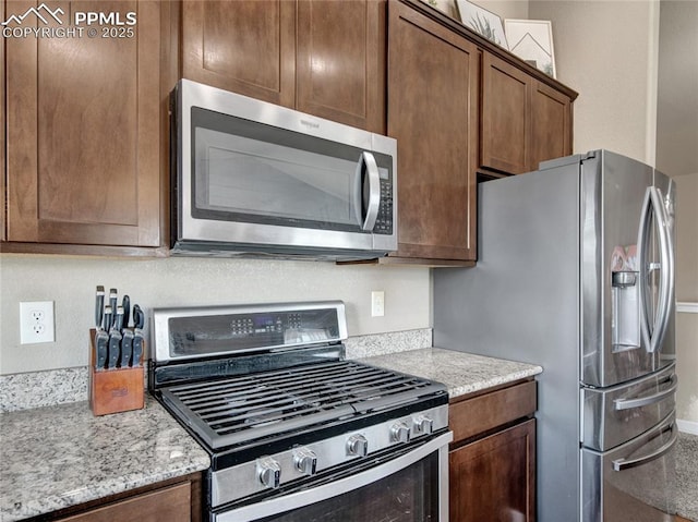 kitchen featuring light stone countertops and appliances with stainless steel finishes