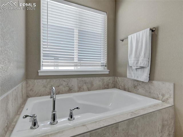 full bath with a garden tub and a textured wall