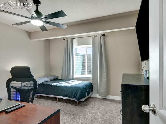 carpeted bedroom with ceiling fan and baseboards