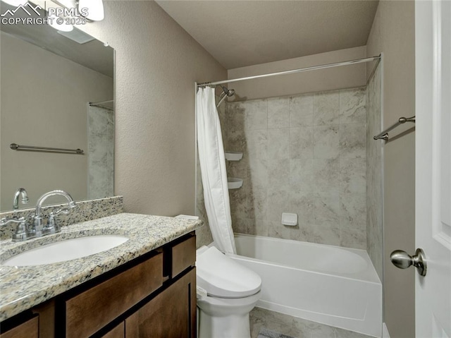 full bath featuring shower / bath combination with curtain, a textured wall, vanity, and toilet