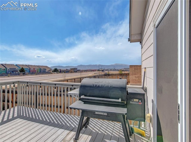 deck with a residential view, a mountain view, and grilling area