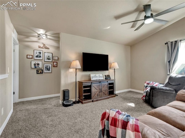 living room with ceiling fan, carpet floors, vaulted ceiling, and baseboards