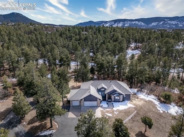 birds eye view of property with a forest view and a mountain view