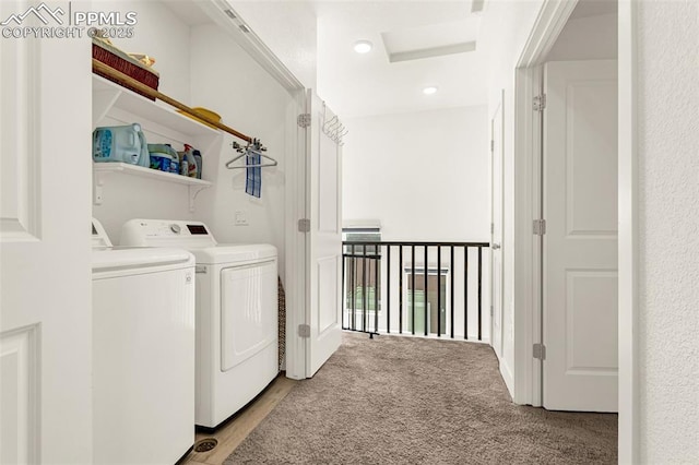 clothes washing area with laundry area, attic access, light colored carpet, and washer and clothes dryer