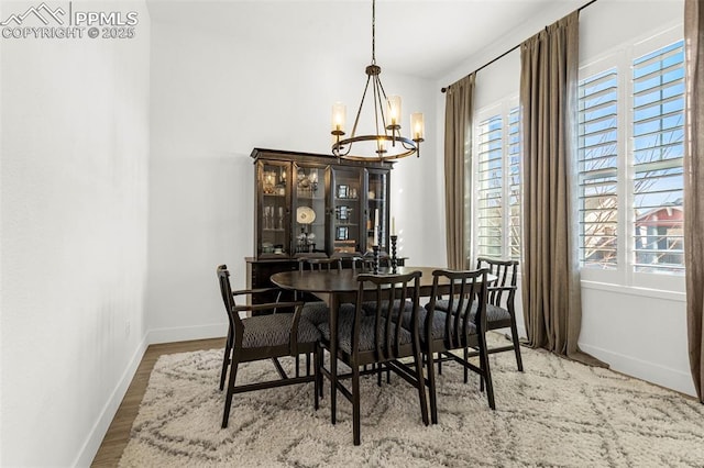 dining room with baseboards, wood finished floors, and a chandelier