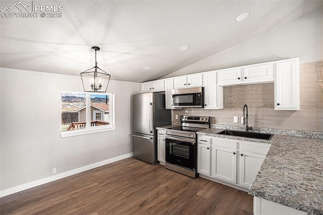 kitchen featuring lofted ceiling, dark wood-type flooring, a sink, appliances with stainless steel finishes, and decorative backsplash