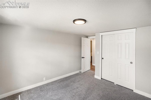 unfurnished bedroom featuring carpet floors, a closet, baseboards, and a textured ceiling