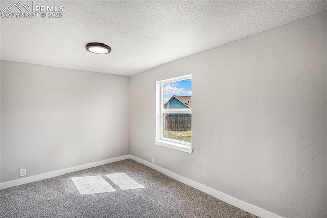 unfurnished room featuring carpet flooring, a textured ceiling, and baseboards