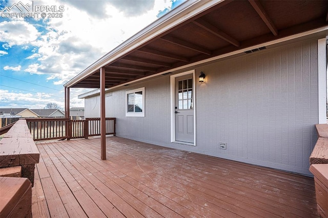 wooden terrace featuring visible vents