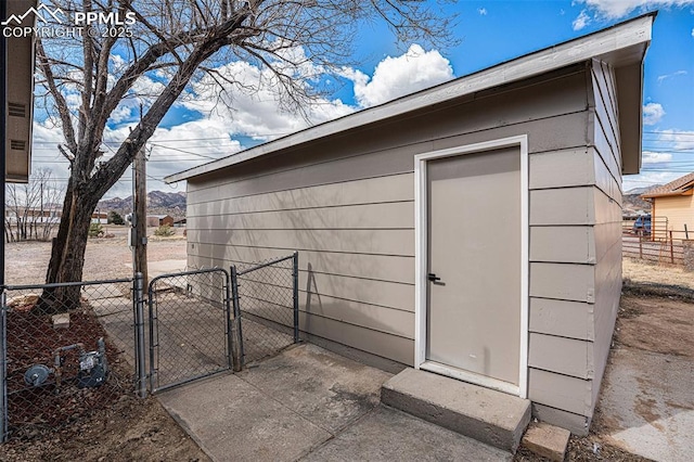 view of outdoor structure with a gate, fence, and an outdoor structure