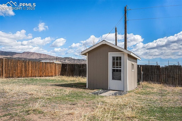 view of shed with a fenced backyard and a mountain view