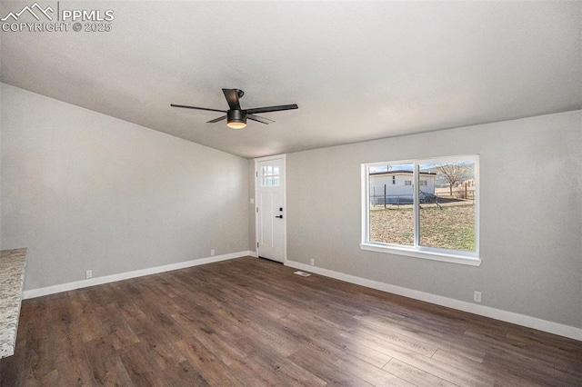 interior space featuring dark wood-style floors, ceiling fan, visible vents, and baseboards