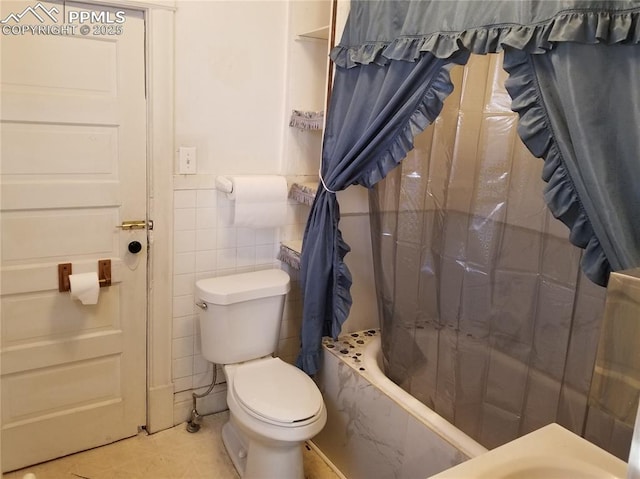 full bath featuring toilet, a wainscoted wall, tile patterned floors, shower / bathtub combination with curtain, and tile walls