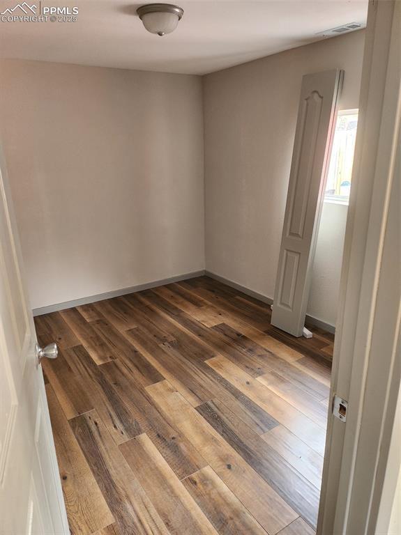 empty room featuring dark wood finished floors and baseboards