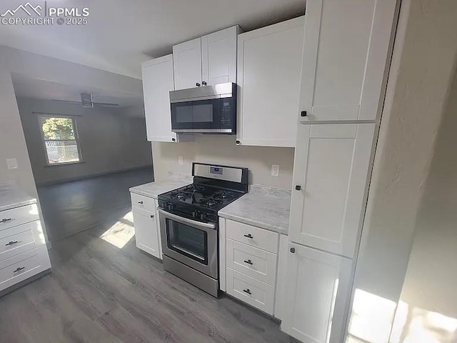 kitchen with stainless steel appliances, white cabinets, ceiling fan, and dark wood-type flooring