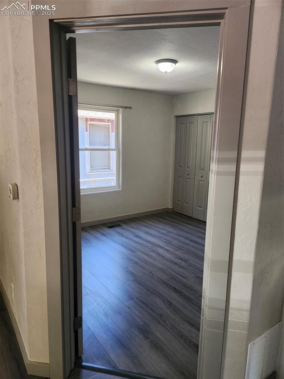 interior space featuring visible vents, baseboards, and dark wood-type flooring