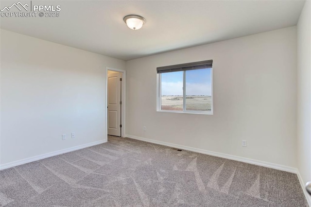 unfurnished room with carpet floors, visible vents, and baseboards