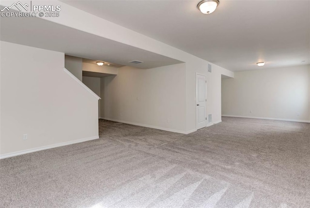 carpeted empty room featuring visible vents and baseboards