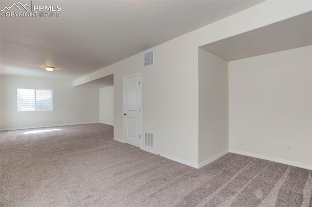 carpeted spare room with baseboards and visible vents