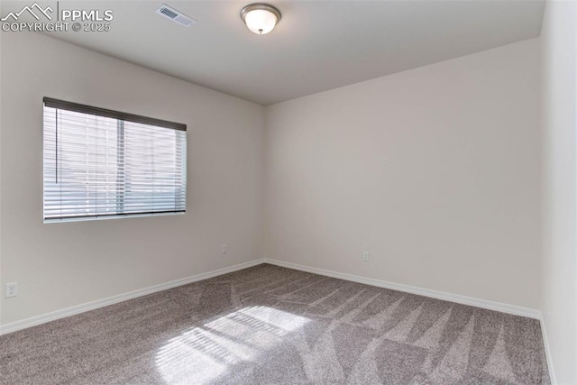 empty room featuring carpet, visible vents, and baseboards