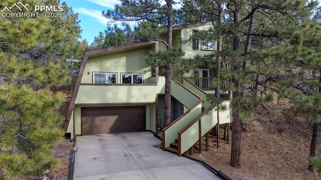 view of front of property with a garage, stairs, and concrete driveway