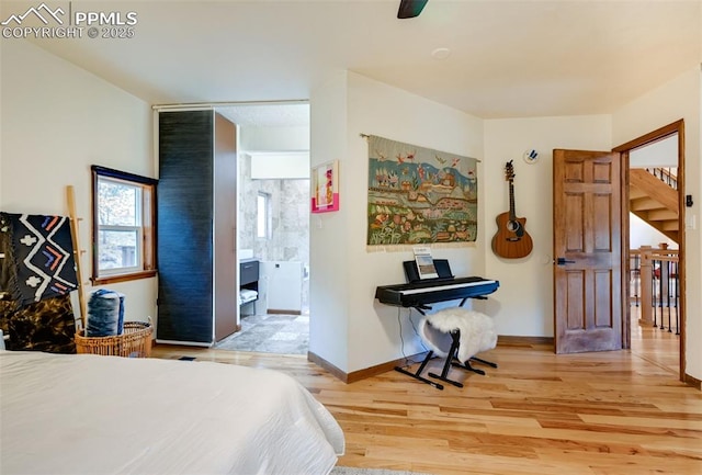 bedroom with baseboards, wood finished floors, and ensuite bathroom