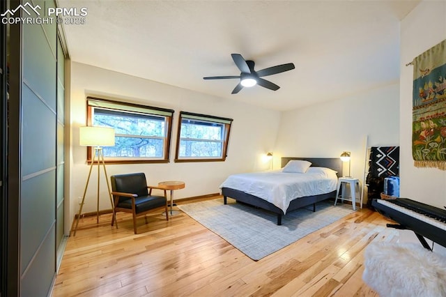 bedroom featuring light wood-style flooring, baseboards, and a ceiling fan