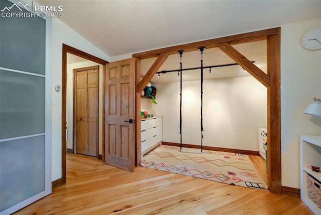 interior space with lofted ceiling, light wood-style floors, and baseboards