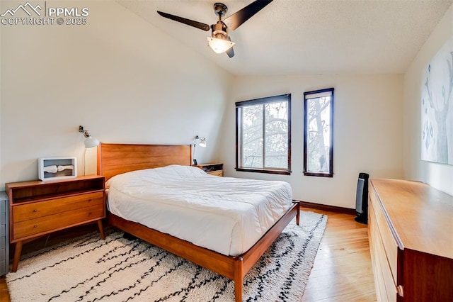 bedroom with lofted ceiling, light wood finished floors, a ceiling fan, and baseboards