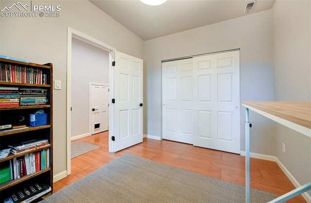 bedroom featuring baseboards, visible vents, and wood finished floors