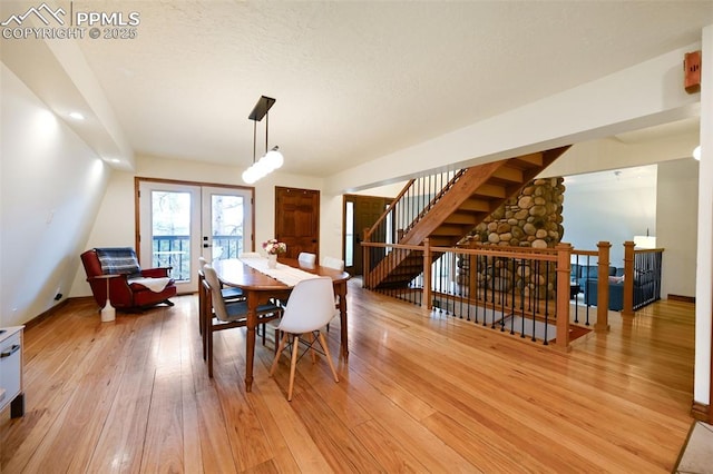 dining area featuring french doors, light wood-type flooring, and baseboards