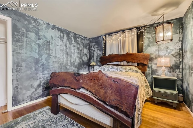 bedroom with wallpapered walls, baseboards, and wood finished floors