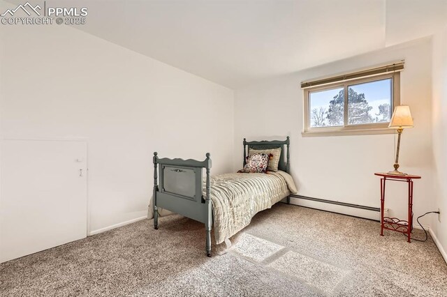 bedroom with baseboard heating and carpet