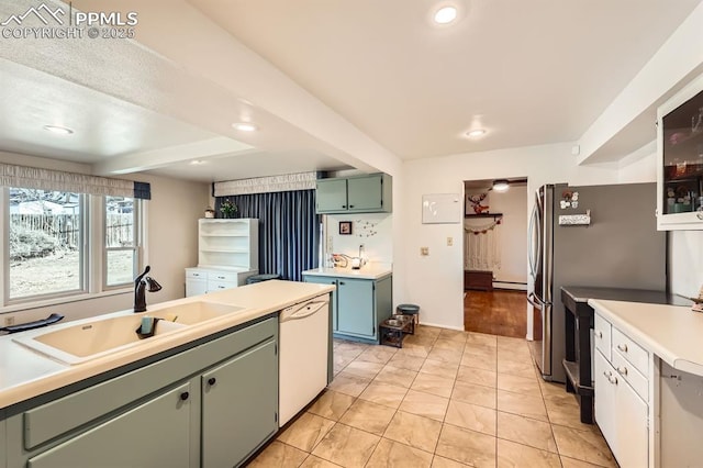 kitchen featuring beamed ceiling, a sink, freestanding refrigerator, white dishwasher, and light countertops