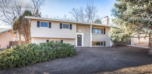 bi-level home with brick siding and a chimney