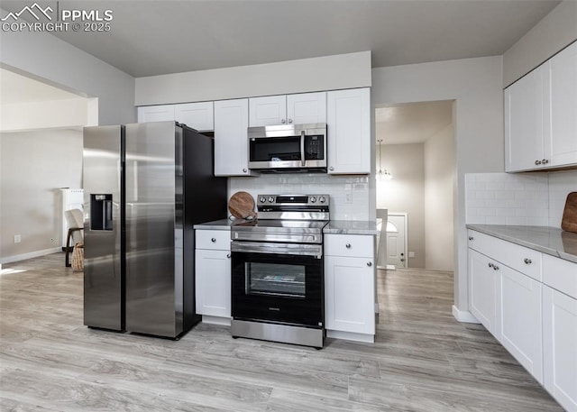 kitchen with appliances with stainless steel finishes, light wood-style floors, and white cabinets