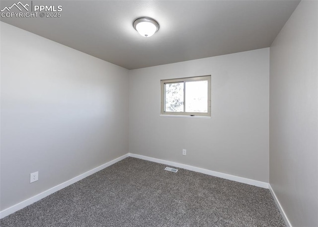 empty room featuring visible vents, dark carpet, and baseboards