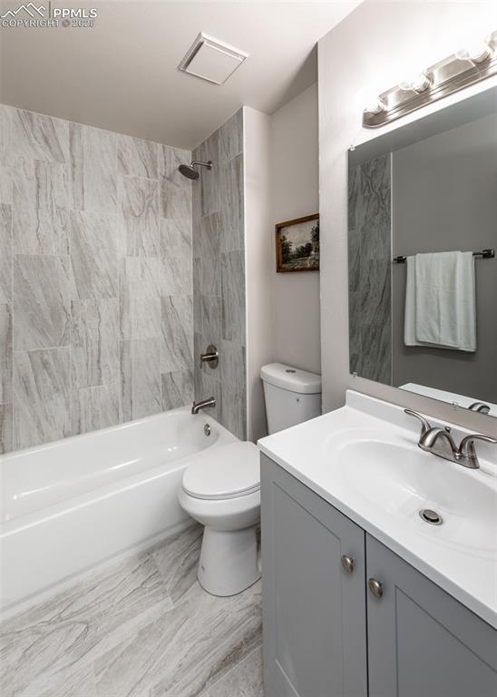 full bathroom featuring visible vents, shower / tub combination, vanity, and toilet