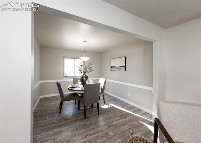 dining area with baseboards and wood finished floors