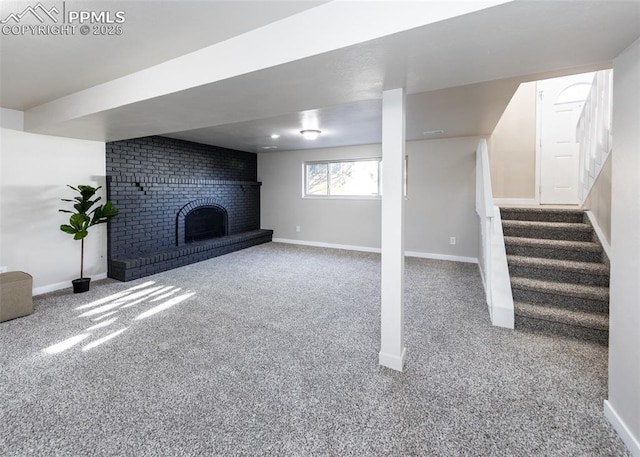 below grade area featuring carpet floors, stairway, a brick fireplace, and baseboards