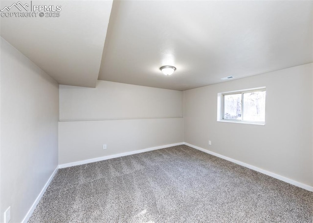 carpeted spare room featuring visible vents and baseboards