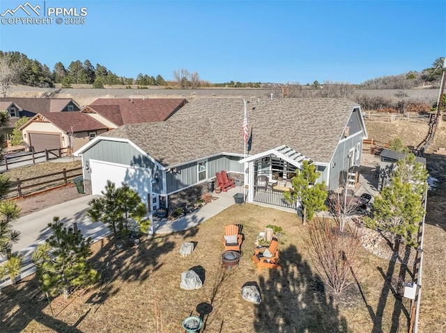 view of front of house featuring driveway, a patio, an attached garage, and fence