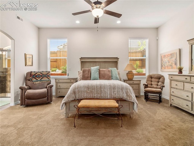 bedroom with arched walkways, carpet flooring, visible vents, and baseboards