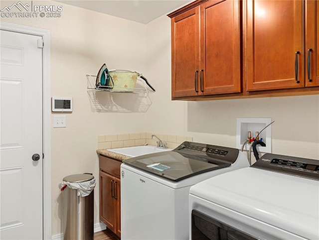 laundry room with washing machine and dryer, a sink, and cabinet space