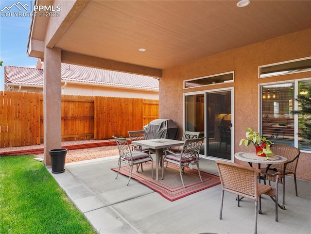 view of patio / terrace with outdoor dining space, fence, and grilling area