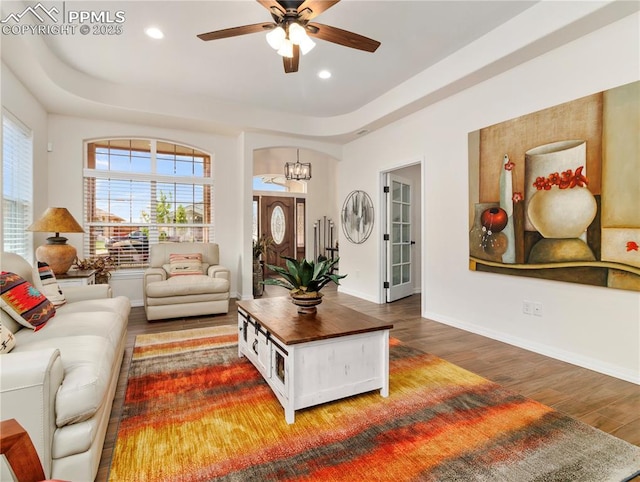 living area featuring ceiling fan with notable chandelier, recessed lighting, wood finished floors, and baseboards