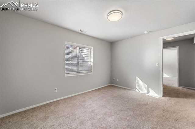 unfurnished room featuring carpet floors, visible vents, and baseboards