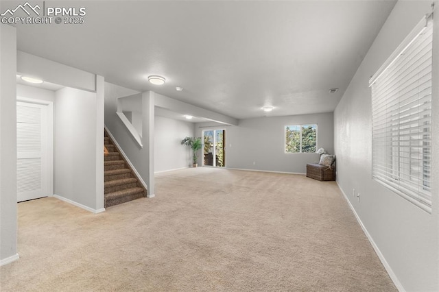 below grade area with carpet, baseboards, and stairs