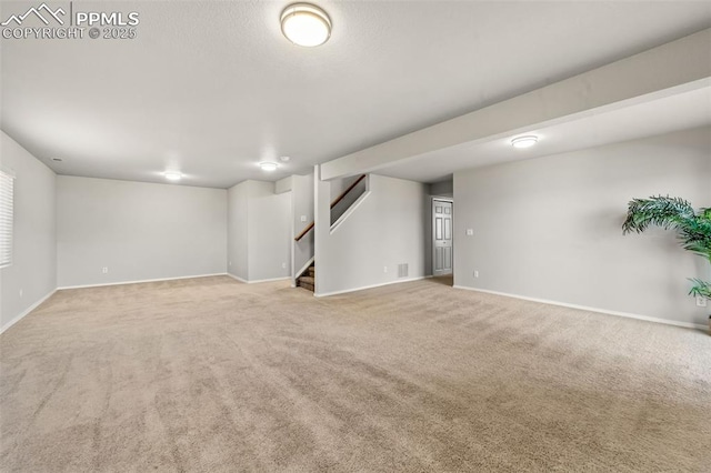 basement featuring light carpet, visible vents, baseboards, and stairs