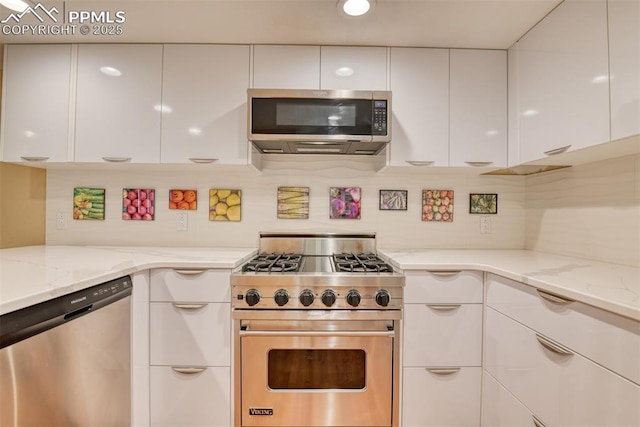 kitchen featuring appliances with stainless steel finishes, white cabinets, light stone counters, and modern cabinets